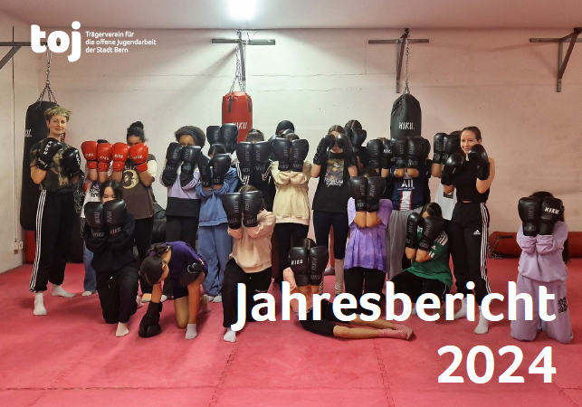 Das Titelbild des Jahresbericht 2024 vom toj. Eine Personengruppe steht in einem Boxkeller. Die Leute haben Boxhandschuhe an und halten diese auf Kopfhöhe. Das Titelbild des Jahresbericht 2024 vom toj. Eine Personengruppe steht in einem Boxkeller. Die Leute haben Boxhandschuhe an und halten diese auf Kopfhöhe.